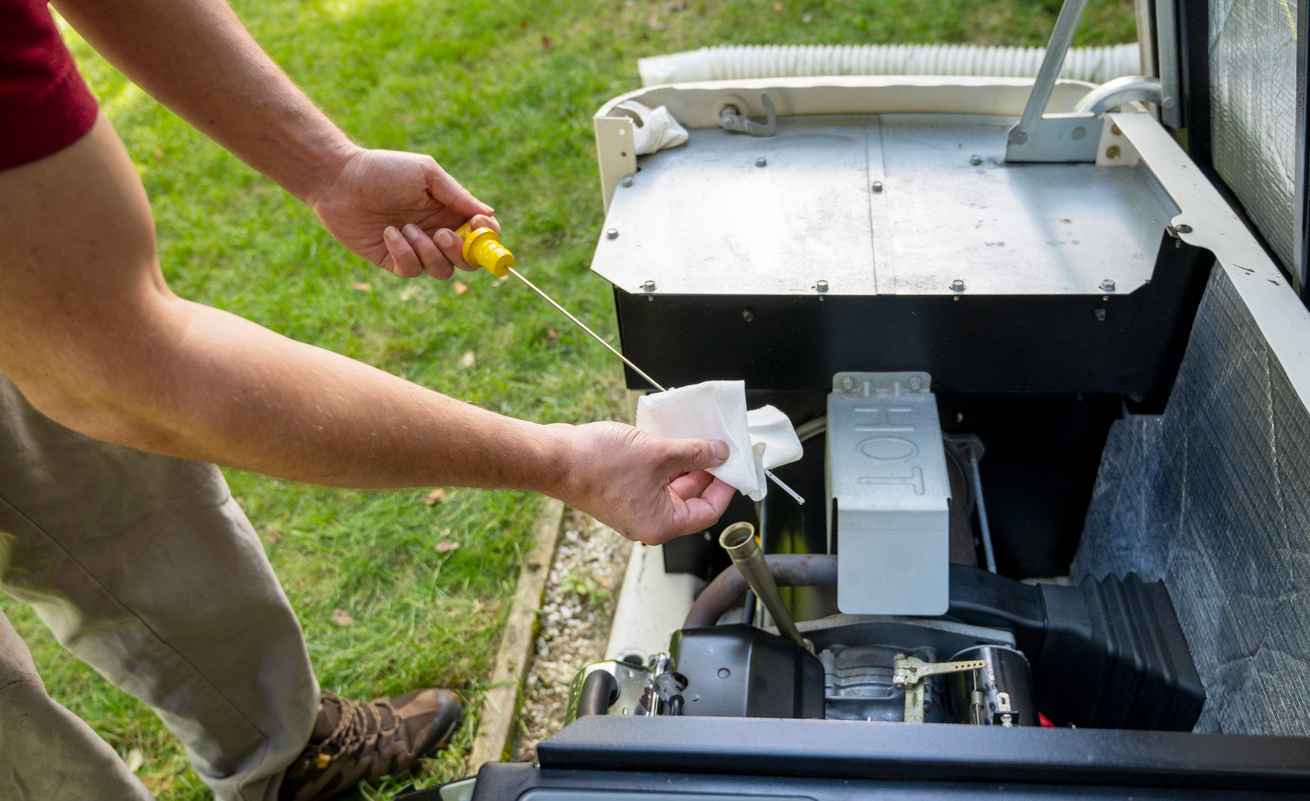 Maintenance Mechanic Inspecting or checking the generator. Man checking engine oil in generator, cleaning oil dipstick, measuring oil level