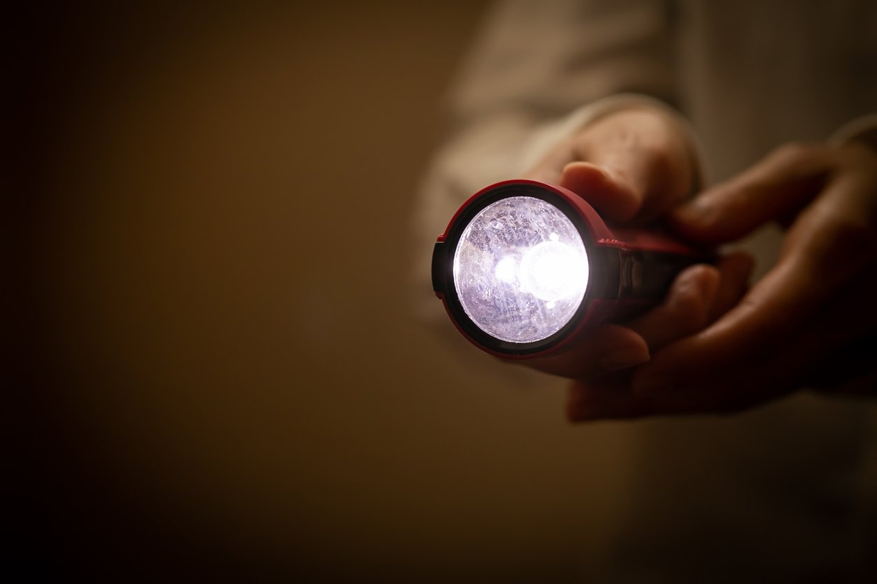 Homeowner using flashlight during a power outage